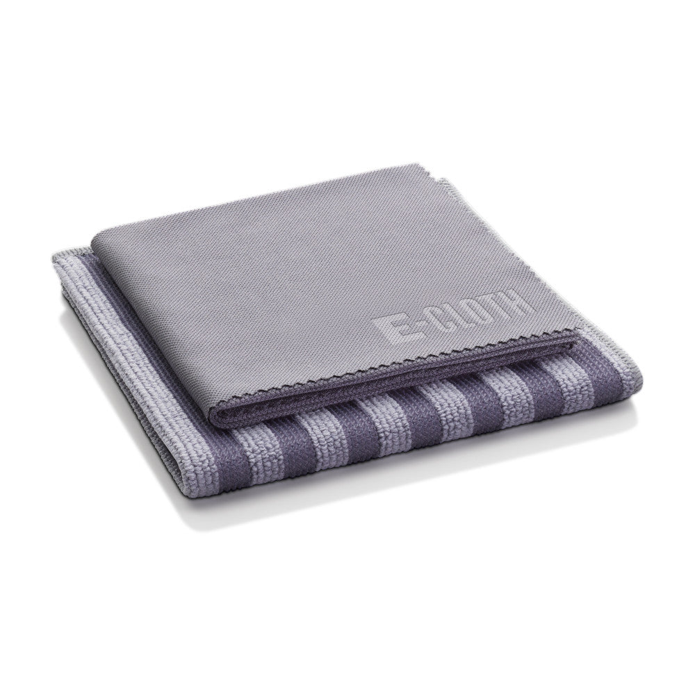 Two neatly folded cleaning cloths from the Stainless Steel Cleaning Kit by E-Cloth, one solid gray with “E.CLOTH” embossed and the other striped, are stacked on a white background—perfect for cleaning stainless steel.