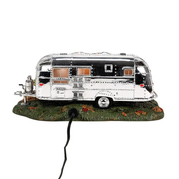 Model of a silver camper on a grassy base with a white background