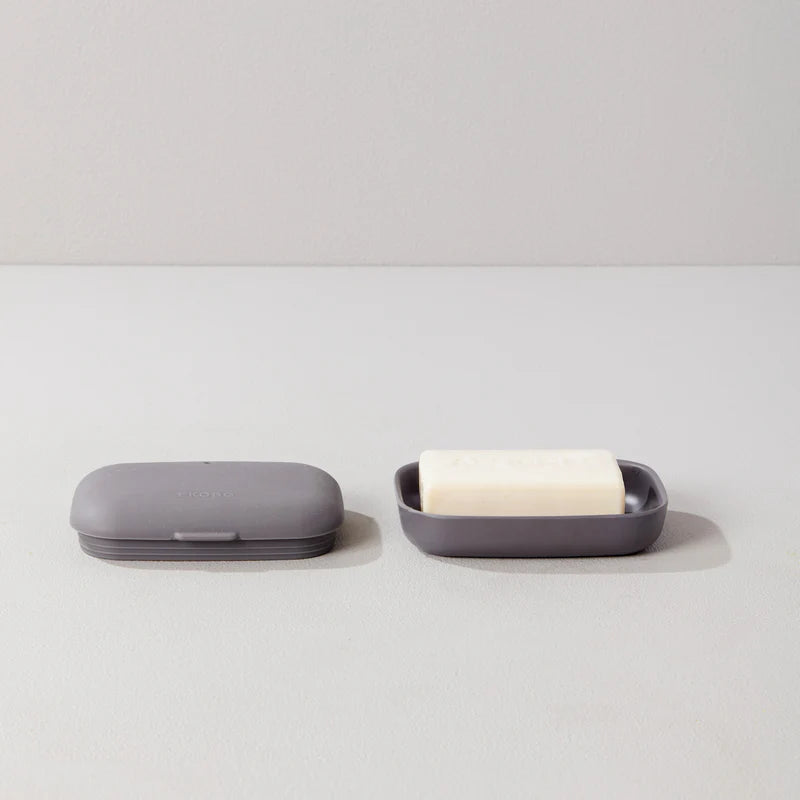 On the left, a closed Bamboo Travel Soap Box with lid from Ekobo sits in gray, while on the right, another box from the set of two is open to reveal a white bar of soap—all displayed on a light gray surface.