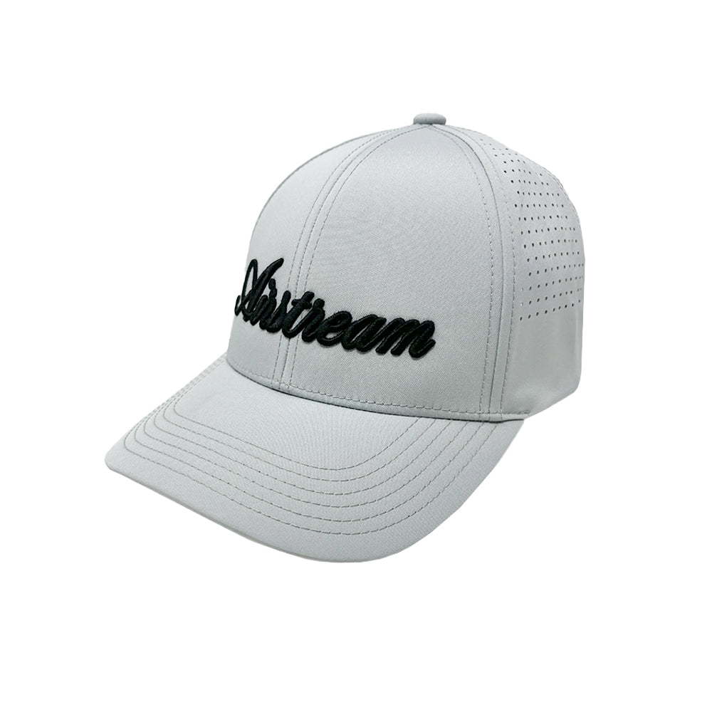 The Airstream Signature Series Hat is a light gray luxury cap featuring bold 3D black script embroidery that spells “Airstream” on the front. Designed for comfort and style, it includes small ventilation holes on the side panels for breathability and showcases premium craftsmanship.
