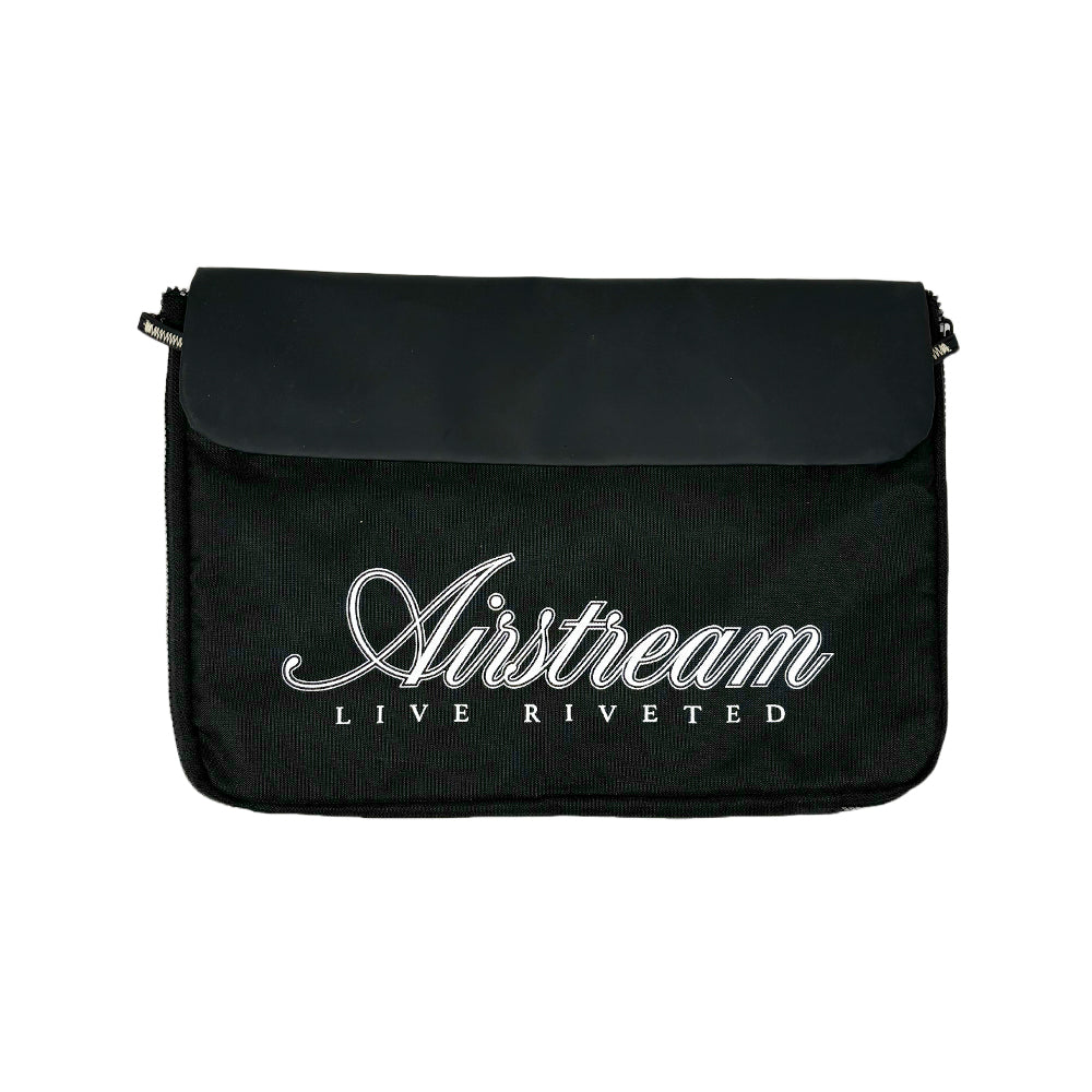 The Airstream Signature Series Laptop Commuter Sleeve is a black fabric messenger bag with “Airstream Live Riveted” inscribed in bold white script on the front flap, featuring a padded laptop compartment for added protection, photographed against a plain white background.