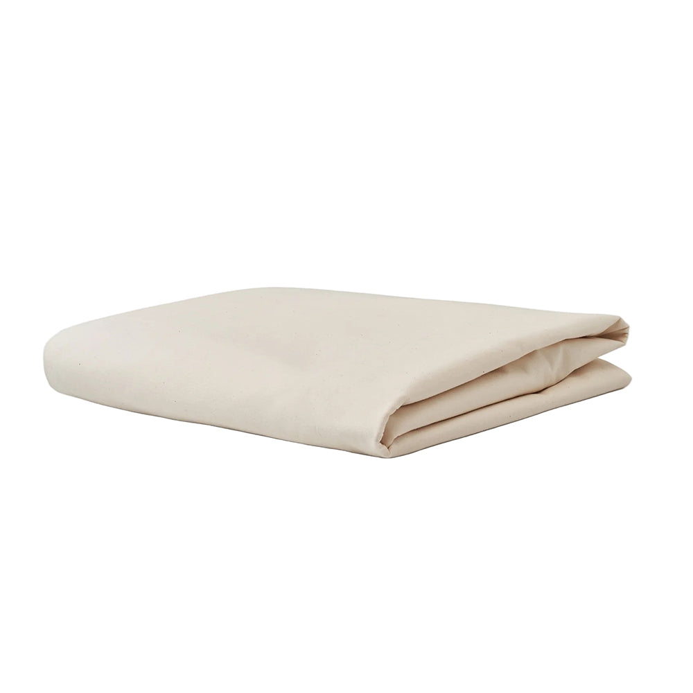 An Airstream Dinette Lounge Cushion Fitted Sheet for Travel Trailers, in a neatly folded light beige or off-white color—perfect as a custom-fit trailer sheet—is placed on a plain white surface.