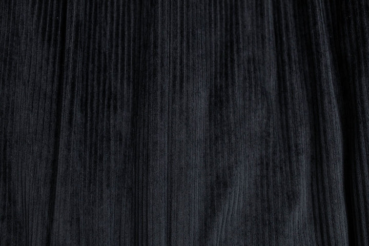 Close-up of the Bryant Luxe Blanket by Beddy’s in black velvet, showcasing its subtle vertical lines and soft, textured surface with a gentle sheen—reflecting the elegant design of this modern blanket.