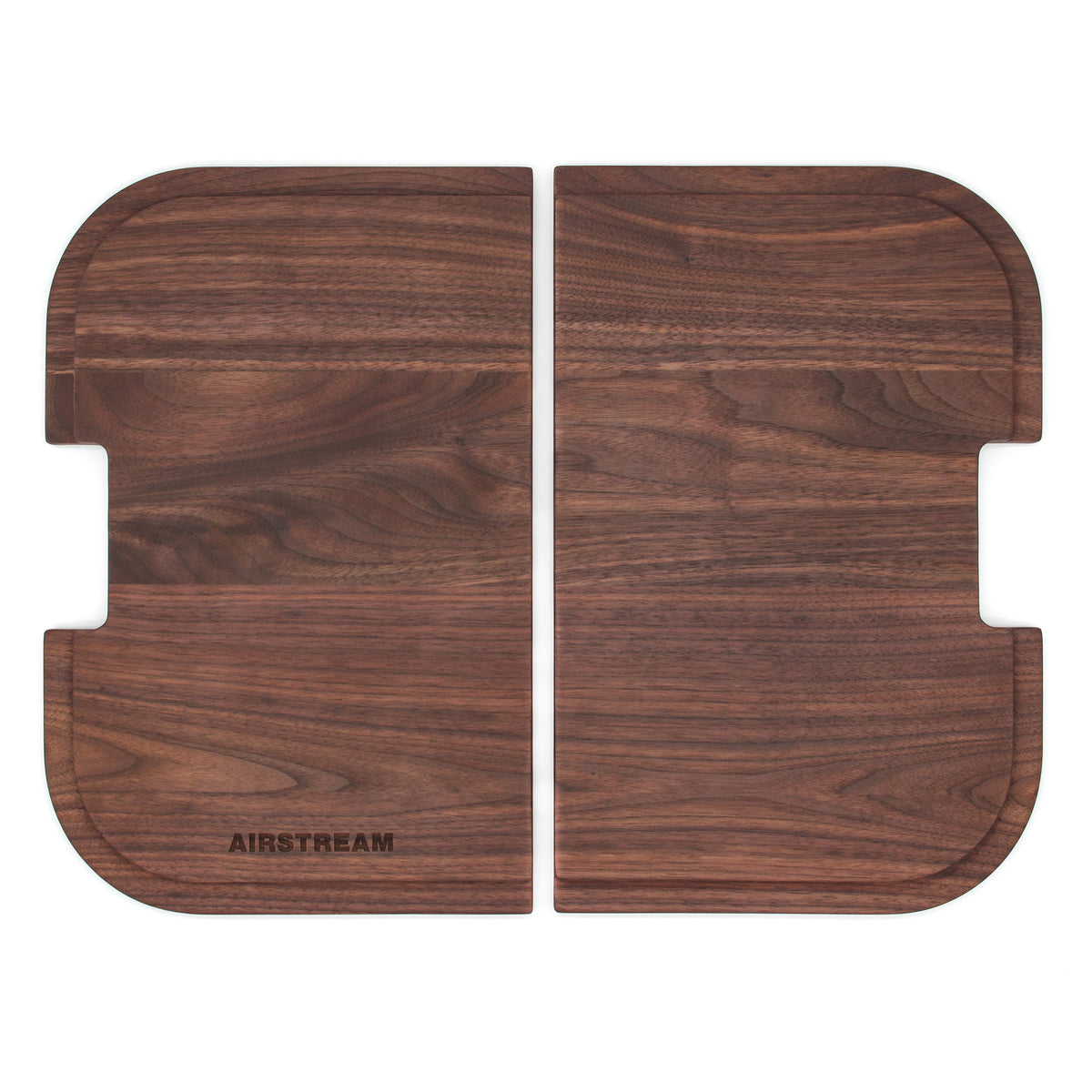Two rectangular Airstream Custom Sink Cutting Boards for Pottery Barn Travel Trailers, each with rounded corners and notched edges, are placed side by side. One board features the word AIRSTREAM engraved in the lower left corner, making it an ideal personalized addition to your kitchen setup.