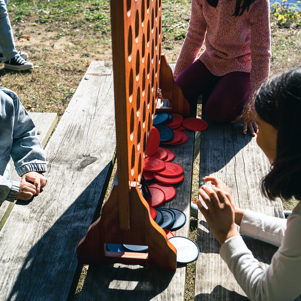 Children Playing With Elakai Giant 4-In-A-Row Game On Picnic Table