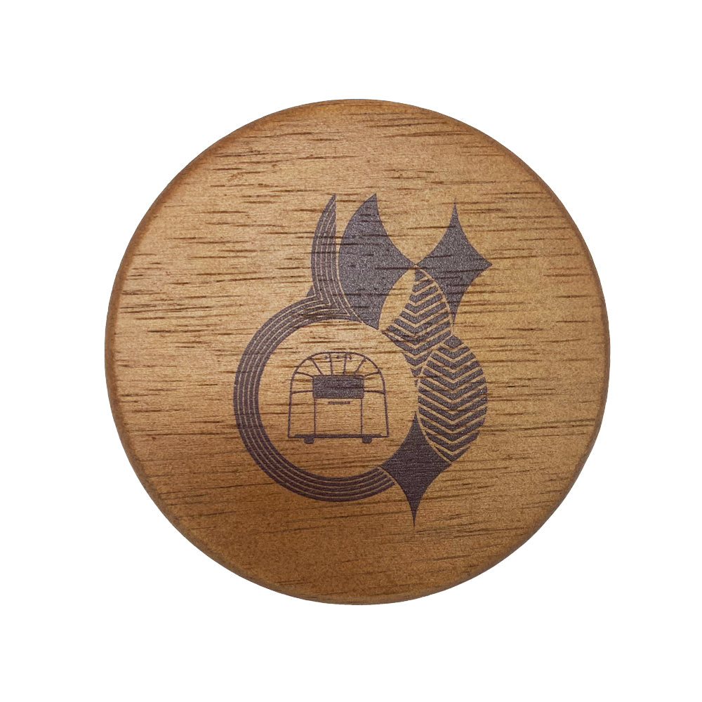 Frank Lloyd Wright x Airstream Coaster Set features circular wooden coasters showcasing a dark, abstract geometric design inspired by Frank Lloyd Wright’s signature style, with a subtle appliance-shaped icon near the center. The natural wood grain is beautifully visible beneath the intricate pattern.