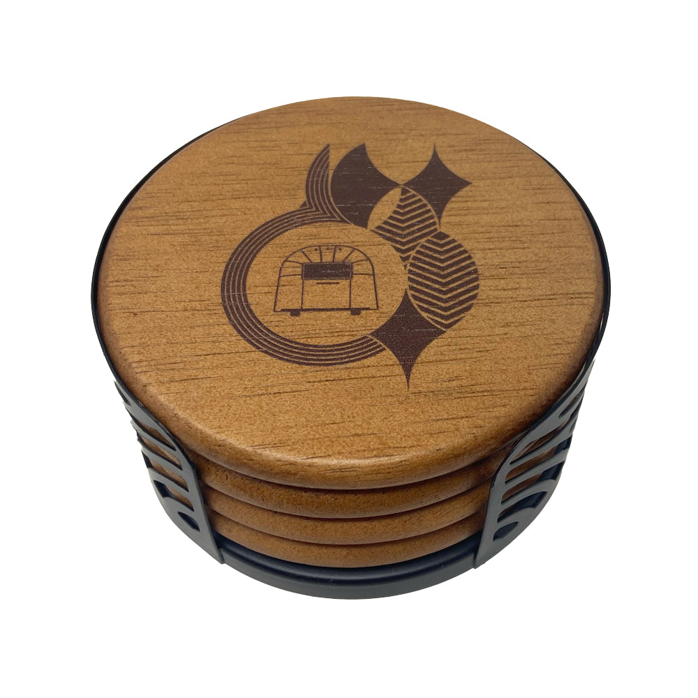 The Frank Lloyd Wright x Airstream Coaster Set features round wooden coasters with a minimalist brown geometric design inspired by Frank Lloyd Wright’s iconic style, all neatly stacked in a sleek black metal holder.