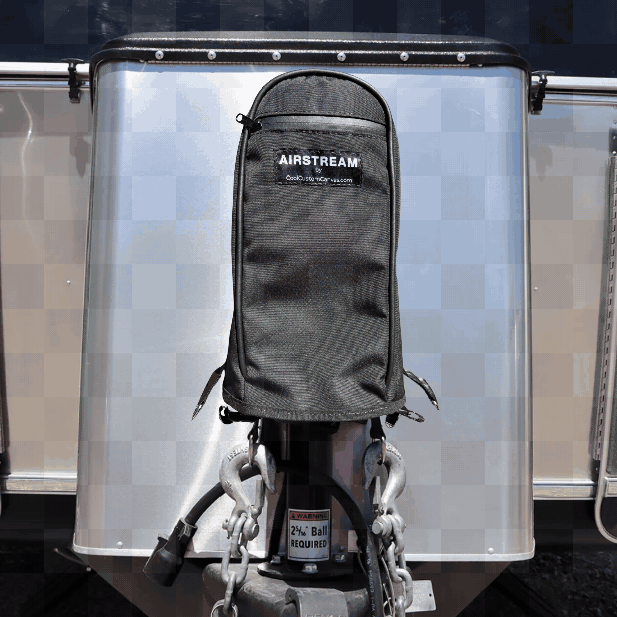 Black water-resistant Airstream Water Resistant Jack Cover protecting the trailer power jack on the front of an aluminum travel trailer.