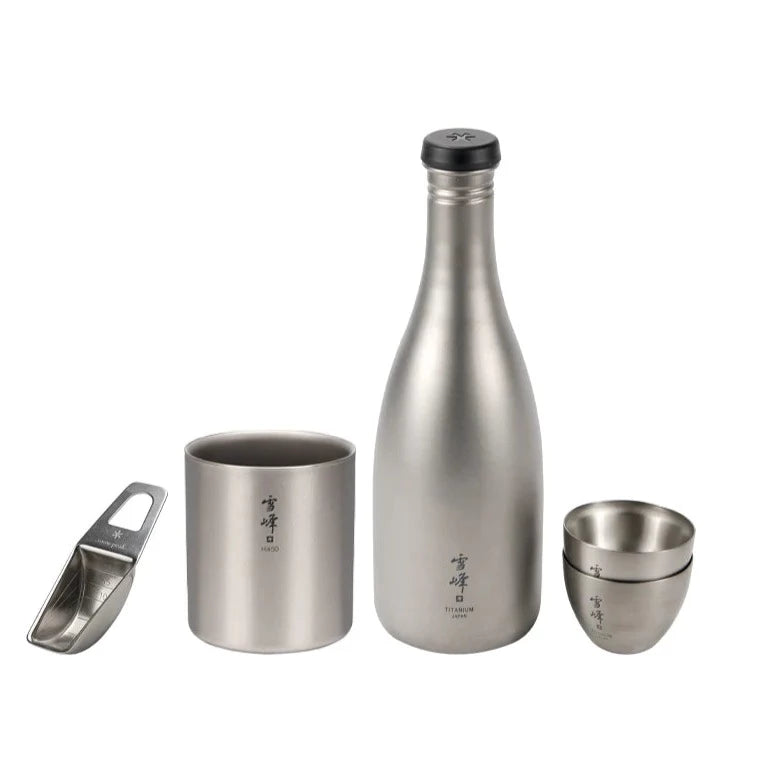 The Snow Peak Bartender Set, crafted from stainless steel and featuring a bottle, two small cups, a larger cup, and a scoop—all engraved with Japanese characters—is displayed on a white background; ideal for elevating your camping cocktail experience or serving as an elegant alternative to the traditional bartender set.