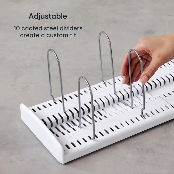 A hand adjusts steel dividers on a white base. Text reads: Adjustable. The Airstream StoreMore Roof Locker Dish Rack by YouCopia features 10 coated steel dividers that can be customized to fit your needs. Rearrange the slots easily to organize kitchen items—perfect for keeping your dishes secure in your Airstream or at home.