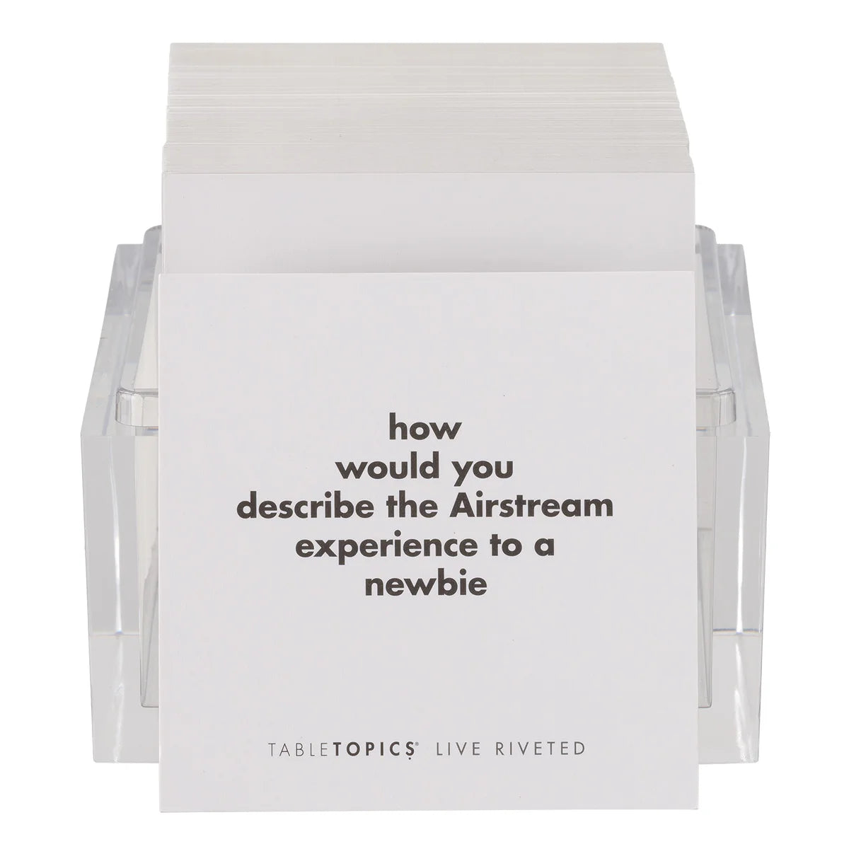 A stack of cards in a clear holder, with the top card reading, “how would you describe the Airstream experience to a newbie”—the perfect addition to your travel collection as the Airstream TableTopics Game for sparking memorable moments and conversations.