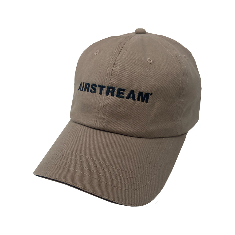 The Airstream Essential Hat is a khaki baseball cap featuring the classic Airstream logo embroidered in bold black capital letters on the front, making it perfect for outdoor adventures and shown against a white background.