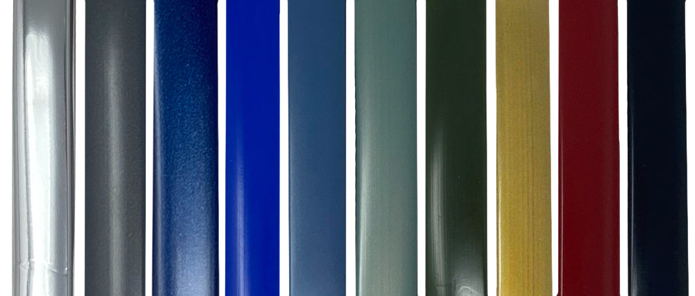 Nine vertical metal panels—each a different color: silver, gray, navy blue, royal blue, teal, green, olive green, gold, and red—are displayed side by side against a white background. Ideal for comparing the range of colors available for the Airstream Premium Replacement Belt Trim for Travel Trailers and selecting the perfect match for your Airstream exterior.