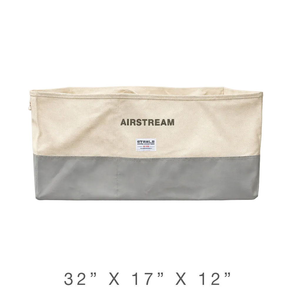 The Airstream x Steele Canvas Twin Bed Storage Bin is a rectangular beige and gray organizer labeled “AIRSTREAM,” crafted from heavy-duty canvas and measuring 32 inches wide, 17 inches deep, and 12 inches tall—ideal for storing essentials under a twin bed floor cabinet.