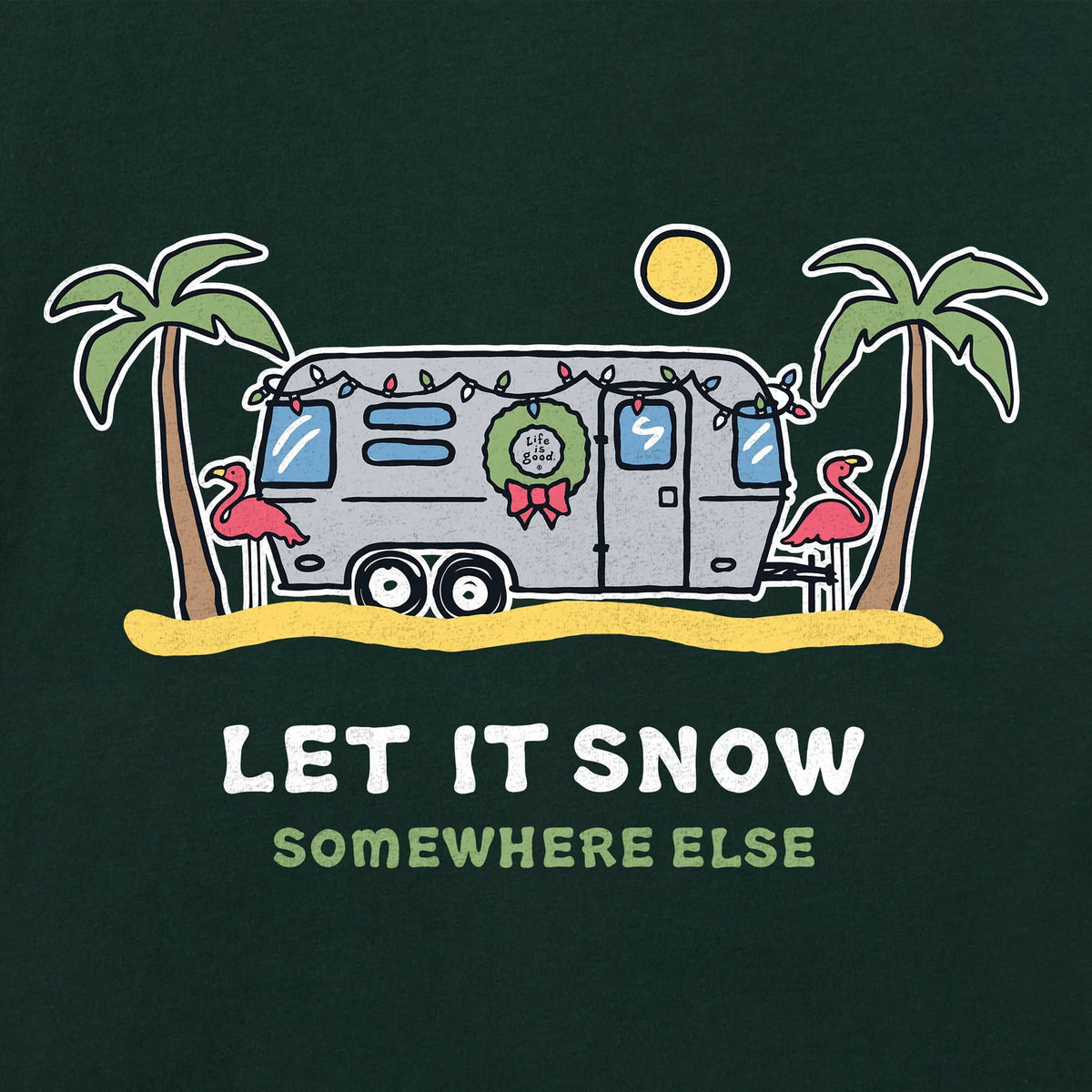 A whimsical Airstream adorned with festive lights, a wreath, and pink flamingos rests between two palm trees beneath the glowing sun. Beneath the scene, the phrase “LET IT SNOW SOMEWHERE ELSE” is displayed. Perfect for winter getaways, the Airstream Let it Snow Crusher T-Shirt by Life is Good® is ideal for anyone who’d trade snowy days for sunny escapes.