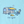 A light blue graphic print featuring a retro camping trailer with a yellow awning, a person sitting in a chair holding a drink, a yellow cat lying on the ground, and the text 'Life is good.'.