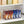 Clear storage bin with Twinkie snack packages inside, placed on a kitchen shelf.