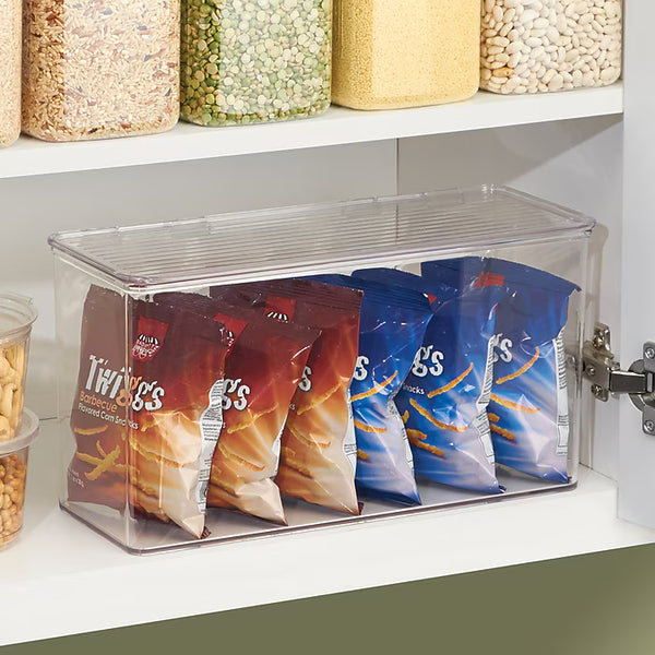 Clear storage bin with Twinkie snack packages inside, placed on a kitchen shelf.