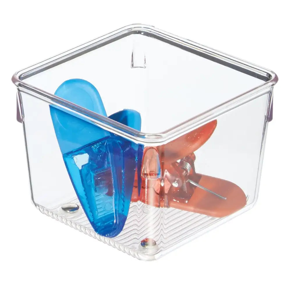A clear Mini Organizer Cube 4 x 4 x 3 holds two large bag clips—one blue and one orange—standing upright inside.