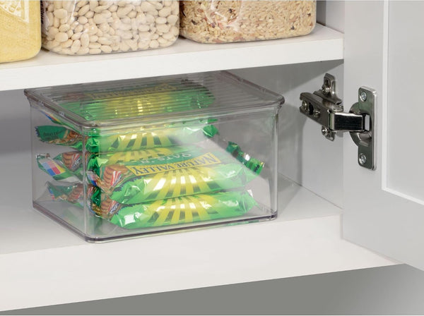 Clear storage bin with snacks inside a cabinet