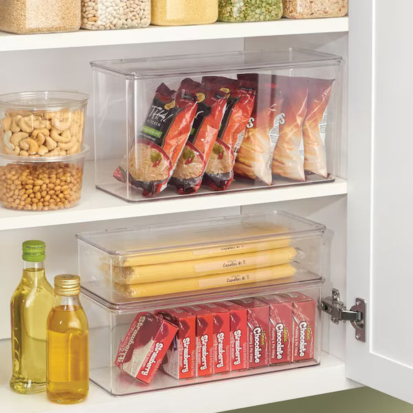 Clear storage bins organizing snacks and pantry items in a kitchen cabinet.