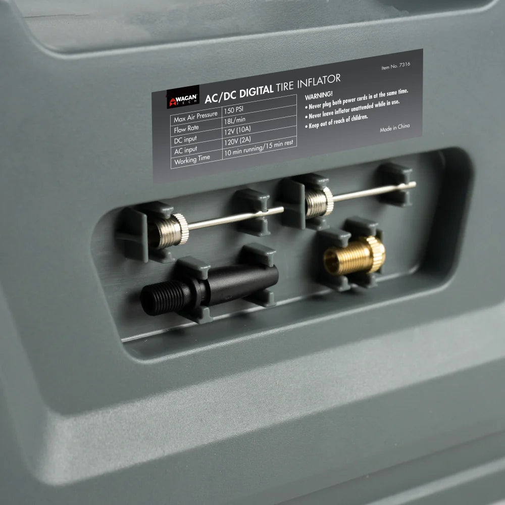 Close-up of the AC/DC Digital Tire Inflator’s accessory storage compartment, displaying four distinct valve adapters securely organized within the gray plastic casing.