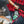 A close-up lifestyle shot of a person organizing green beverage cans inside a red and black buffalo plaid cooler bag or tent pocket.