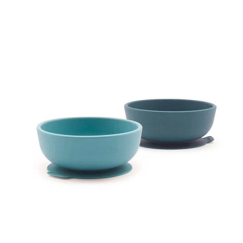 Two Silicone Suction Bowls for Kids by Ekobo in different shades of blue, designed for hassle-free toddler feeding, are displayed on a white background. The front bowl is light blue and the one behind is a darker blue—making this Silicone Suction Bowl Set perfect for helping little ones enjoy mealtime.