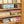 Wooden shelves with clear storage bins containing various food items and snacks.