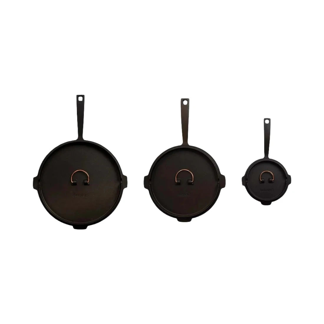 Three All-In-One Cast Iron Skillets by Barebones, each with Dutch Oven-style lids, are displayed side by side in small, medium, and large sizes on a white background. Every pre-seasoned skillet is designed with a long handle and a centered metal loop atop the lid.