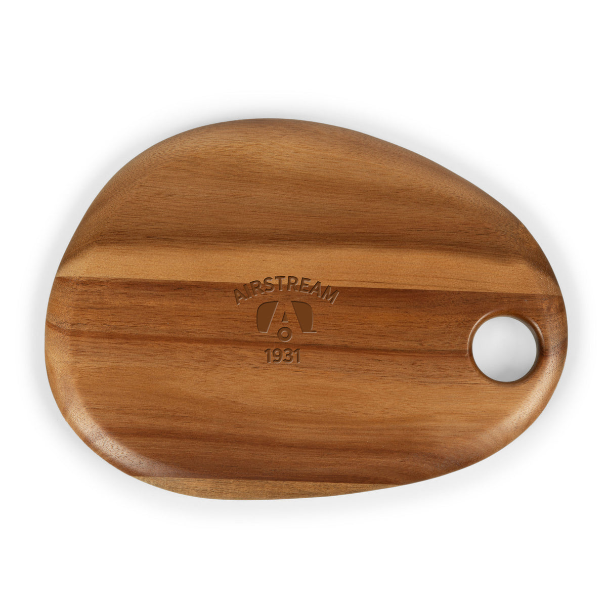 The Airstream Serving Boards feature an irregularly shaped acacia wood design with a smooth finish, a circular hole in one corner, and “Airstream 1931” engraved above a stylized A logo in the center. Perfect for serving appetizers or cheeses.