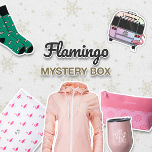 Flamingo-themed mystery box items: green socks with flamingos, Airstream camper sticker, flamingo print cloth, pink jacket, pink pouch, and silver tumbler. Flamingo Mystery Box text in the center.