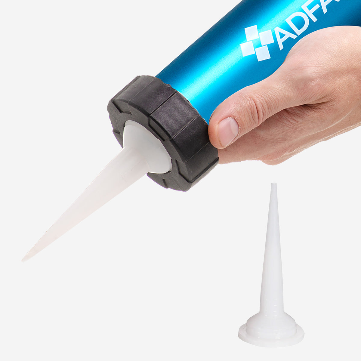A hand holds the Airstream Adseal Gun, featuring a blue body with a white nozzle for precise sealant application; an additional nozzle rests on the white surface below.
