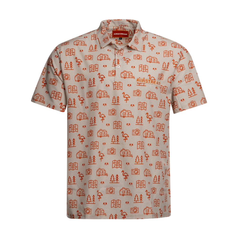 The Airstream Conversational Polo is a beige short-sleeve shirt crafted from breathable recycled polyester, adorned with a lively orange travel-themed pattern featuring trees, cameras, books, and flamingos. It also includes the distinctive Airstream logo printed on the left chest.