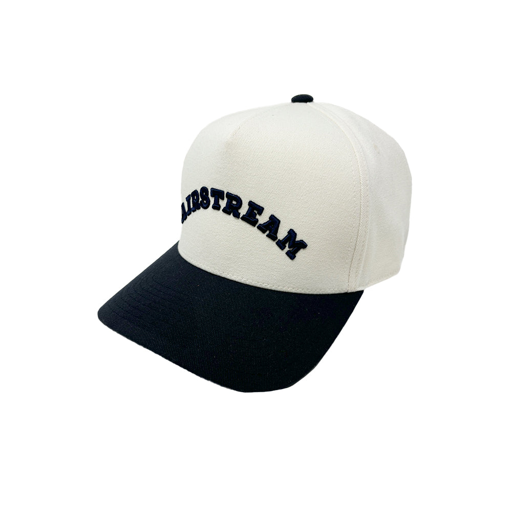 Introducing the Airstream Heritage Arc 5-Panel Snapback Hat, featuring a crisp white crown and a sleek black brim. The bold “AIRSTREAM” lettering is embroidered in classic black on the front, highlighting the iconic Heritage Arc style. This snapback hat blends timeless design with contemporary appeal.
