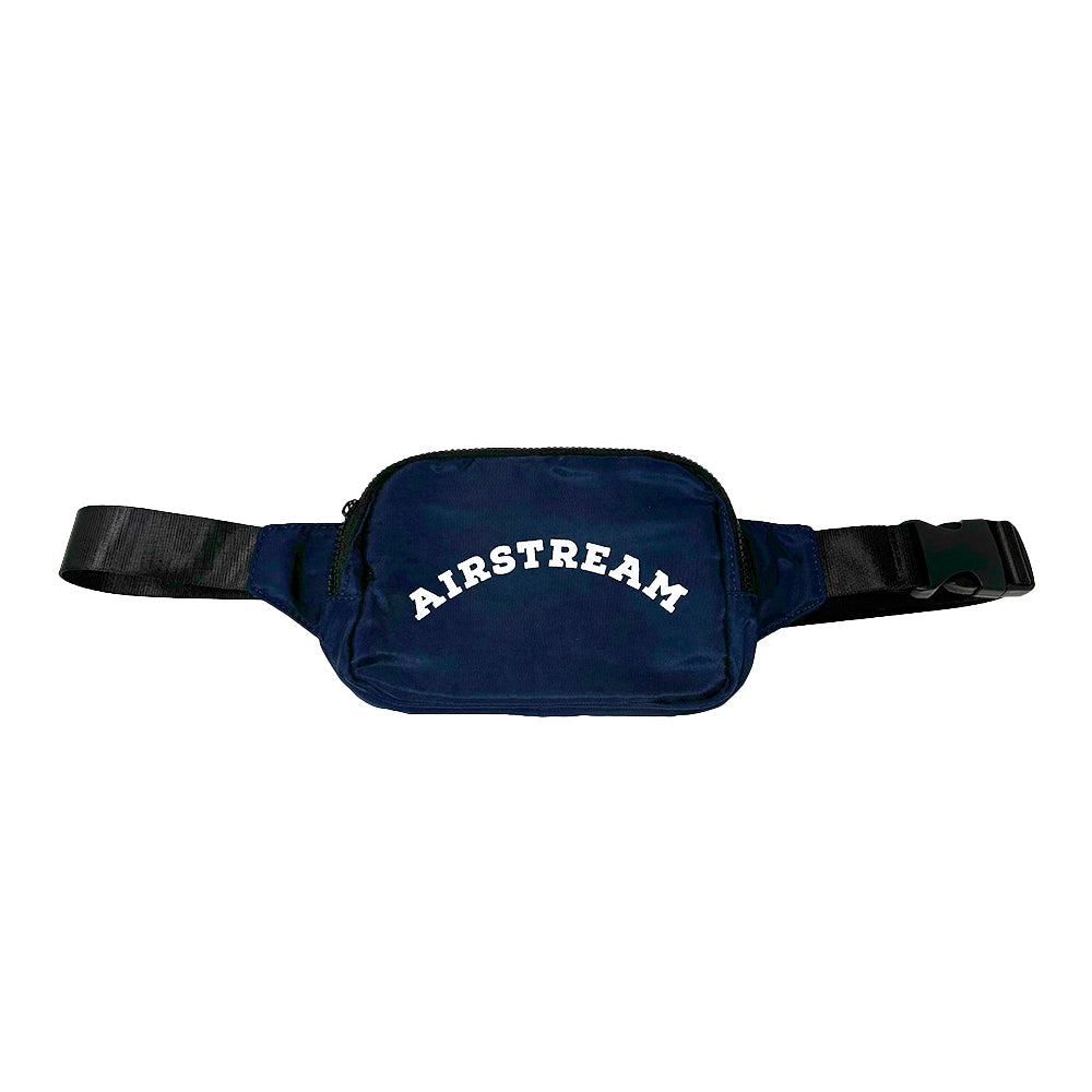 Introducing the Airstream Heritage Arc Anywhere Belt Bag—a navy blue fanny pack featuring a black adjustable strap and clasp. The front pocket is boldly emblazoned with “AIRSTREAM” in crisp white capital letters, offering stylish and hands-free convenience wherever your travels take you.