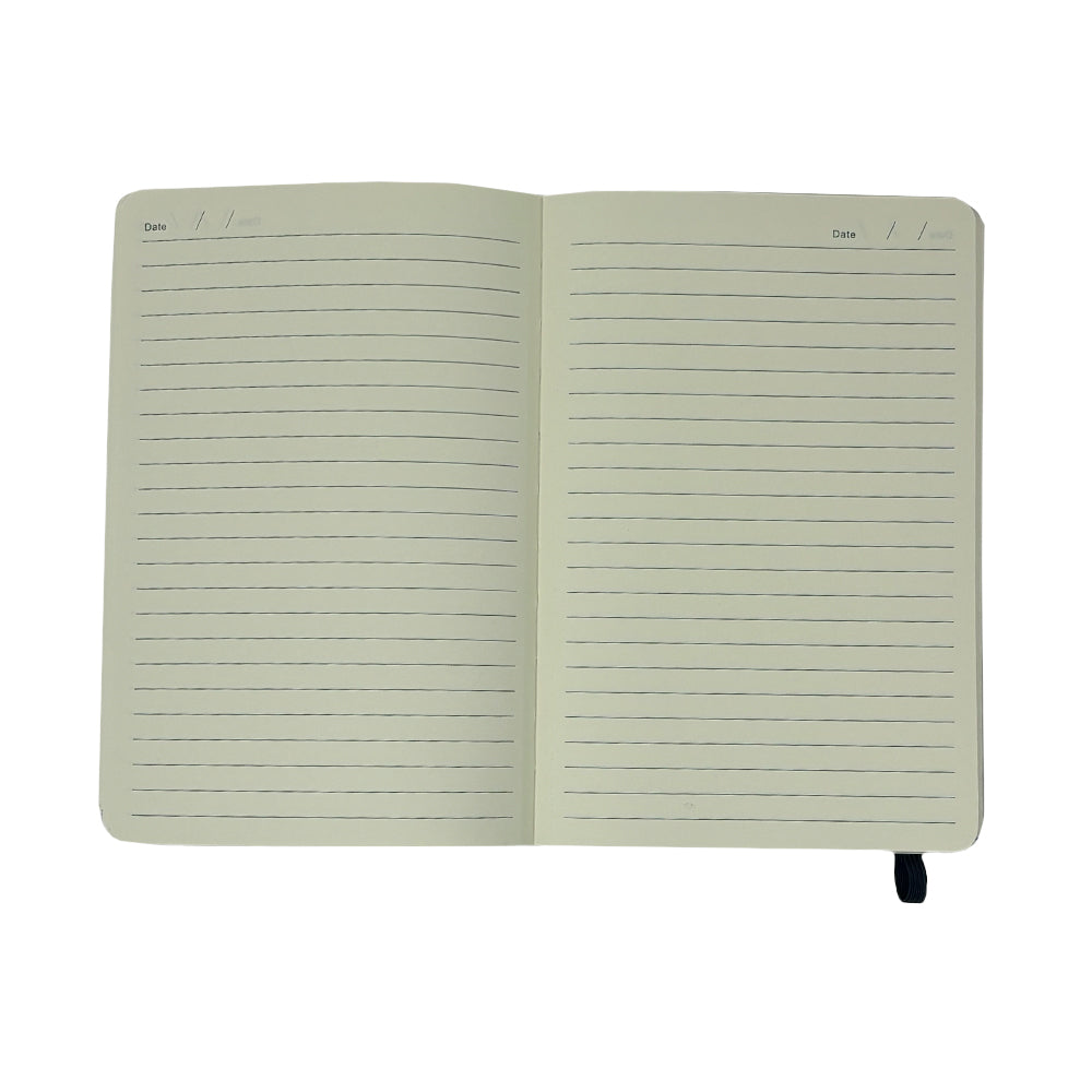 The Airstream Heritage Arc Soft Cover Journal lies open, displaying its lined pages with a designated space for the date at the top of each page. A black ribbon bookmark peeks out from the bottom right, ready to keep your place. Set against a white background, this portable journal showcases simple elegance.