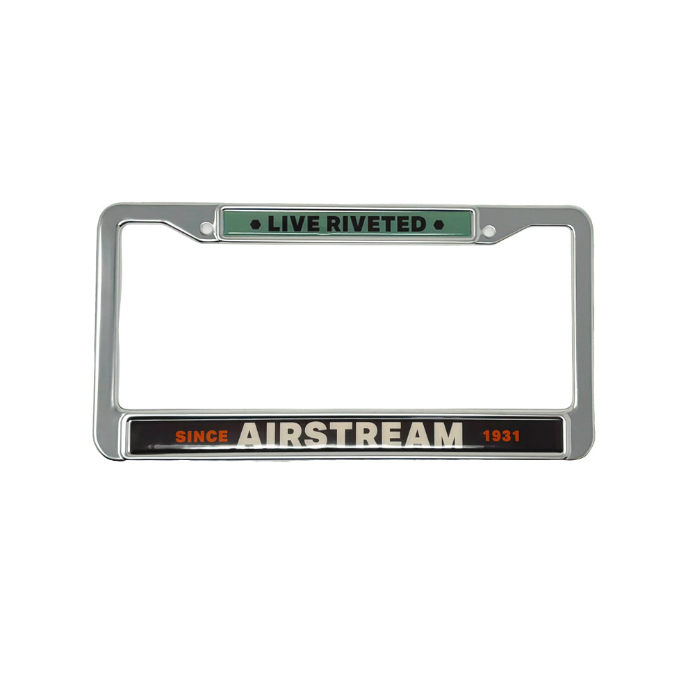 Showcase your passion for Airstream journeys and adventure road accessories with the Airstream Live Riveted 1931 License Plate Frame, featuring a chrome finish and bold “LIVE RIVETED” on top and “SINCE AIRSTREAM 1931” on the bottom in black, white, and orange text.