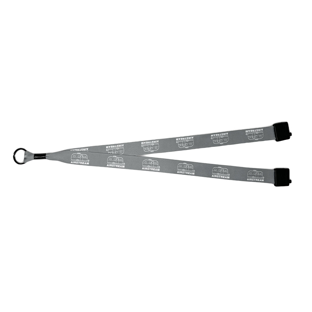 Introducing the Airstream Mini Trailer Lanyard in gray, featuring a sleek design with repeated white logos and text. Equipped with a metal keyring and black plastic attachments at each end, this lanyard makes a distinctive accessory for any set of keys.