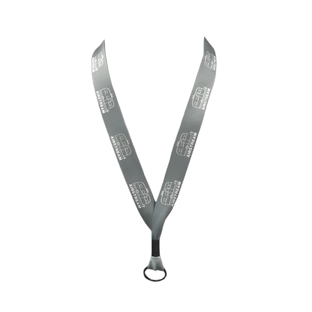 Introducing the Airstream Mini Trailer Lanyard—a unique accessory featuring a sleek gray design with “Audio Visual” and icons of a camera and speaker printed repeatedly in white. This lanyard is finished with a black metal clip at the bottom, perfect for attaching your essentials.