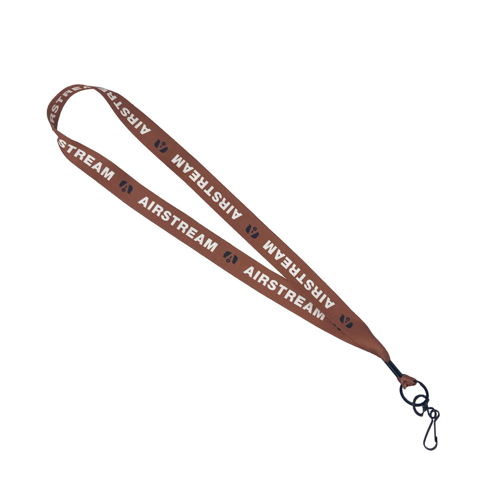 The Airstream Pastel Lanyard features a brown, stylish design with repetitive white AIRSTREAM text and small circle logos, and is equipped with a black clip at the end for attaching keys or badge holders. This quirky accessory is shown laid flat on a white background.
