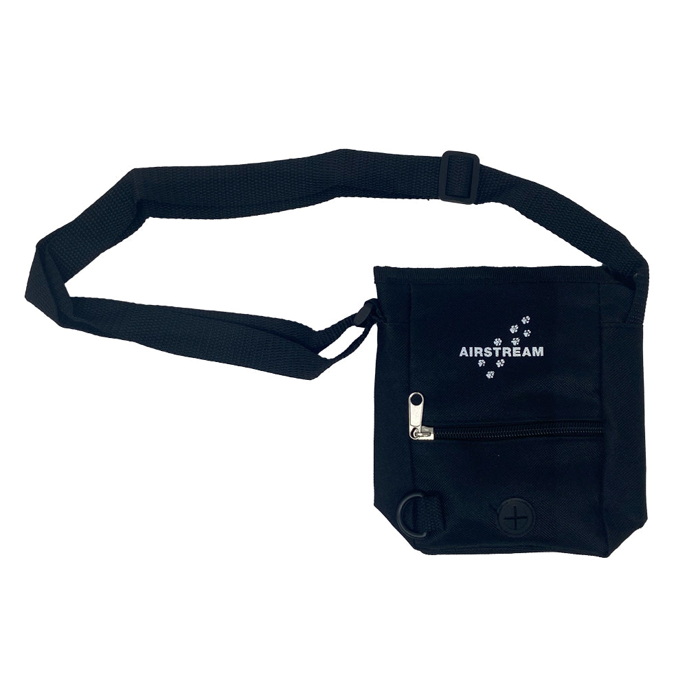 Introducing the Airstream Pet Treat and Bag Carrier—a black waist bag featuring an adjustable strap, front zipper pocket, and the signature AIRSTREAM logo with paw prints. Designed for convenience, it includes a handy poop bag dispenser—a discreet round opening at the bottom right corner—making it the perfect pet treat pouch for dog walks and outdoor adventures.