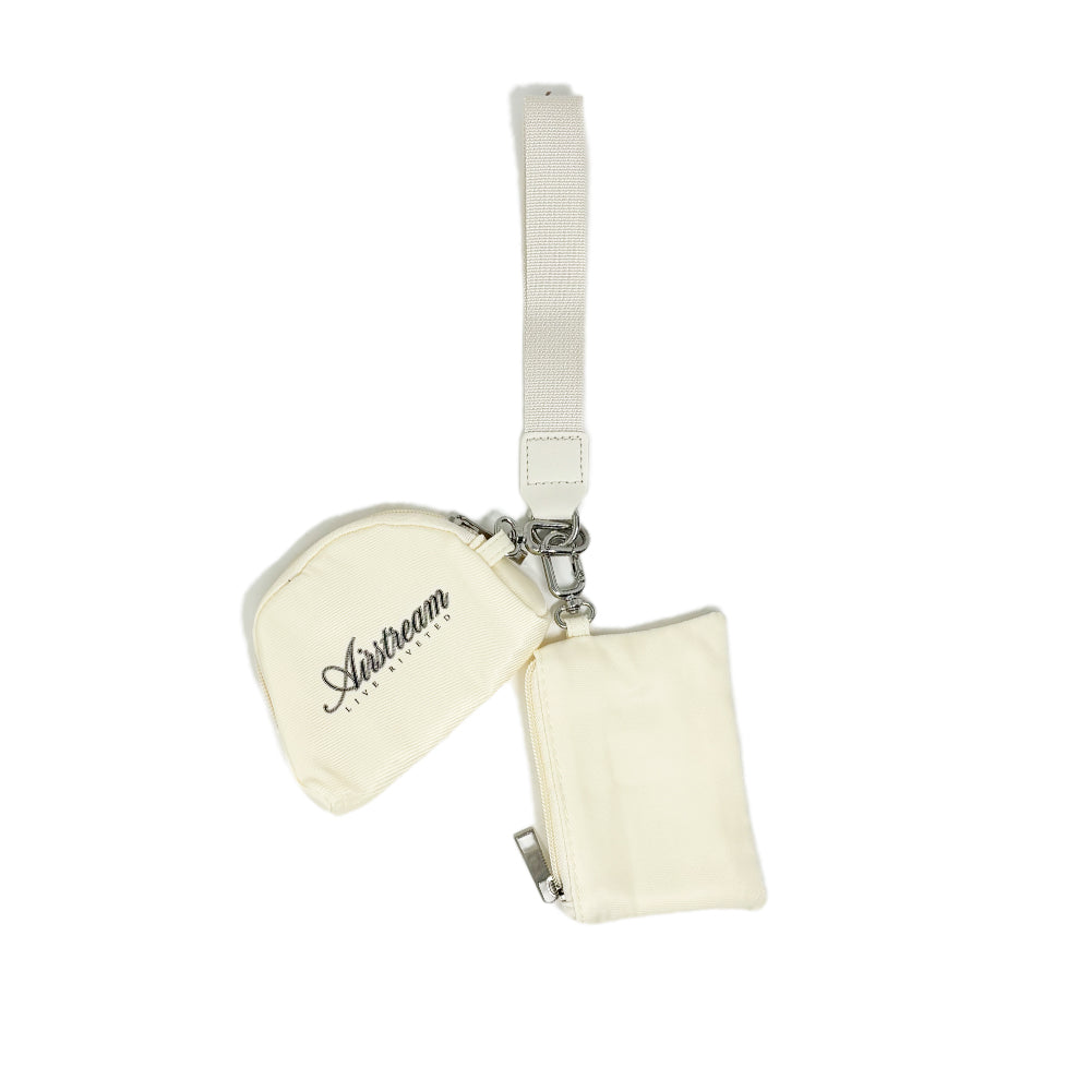 The Airstream Signature Series Dual Pouch Wristlet Wallet features two compact, off-white fabric pouches attached to a coordinating wrist strap for convenient carrying. One pouch is adorned with the “Airstream” logo, and both are equipped with zippers and key clip attachments, making this wallet the ideal travel companion and a thoughtful gift for women.