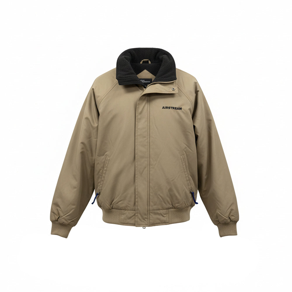 Presenting the Airstream Voyager Jacket—a tan, high-collared jacket featuring a front zipper concealed by a flap, two side pockets, ribbed cuffs and hem, and “AIRSTREAM” embroidered on the left chest. Designed for maximum style and performance, this jacket provides wind and water resistance as well as a heavyweight fleece lining for outstanding warmth. Shown against a plain white background.