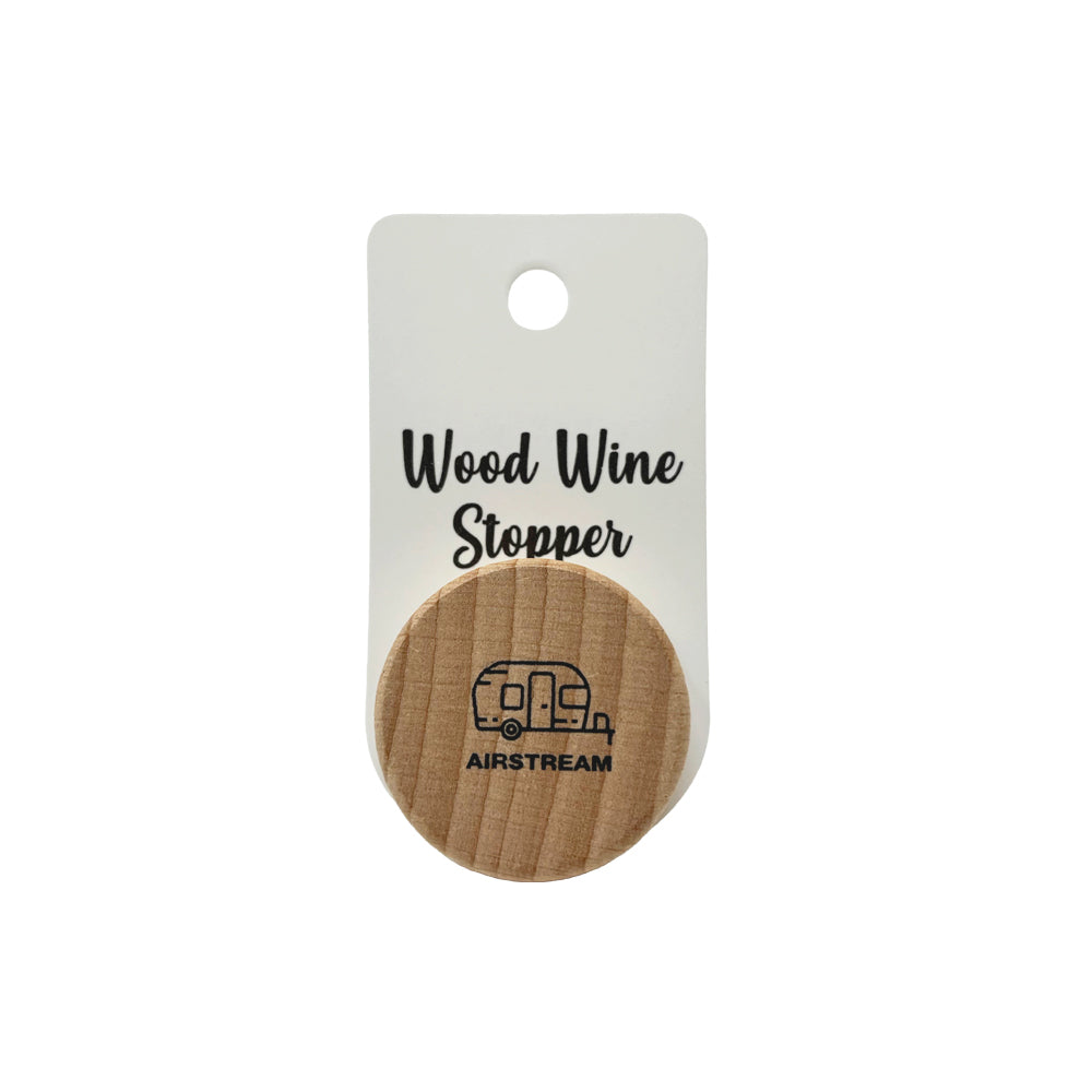Set against a clean white background, the Airstream Wine Stopper is elegantly packaged, showcasing the product name “Wood Wine Stopper” along with a finely engraved travel trailer graphic above the word “AIRSTREAM” on its wooden top. This chic accessory merges functional wine preservation with iconic travel trailer design, making it an ideal choice for wine enthusiasts everywhere.