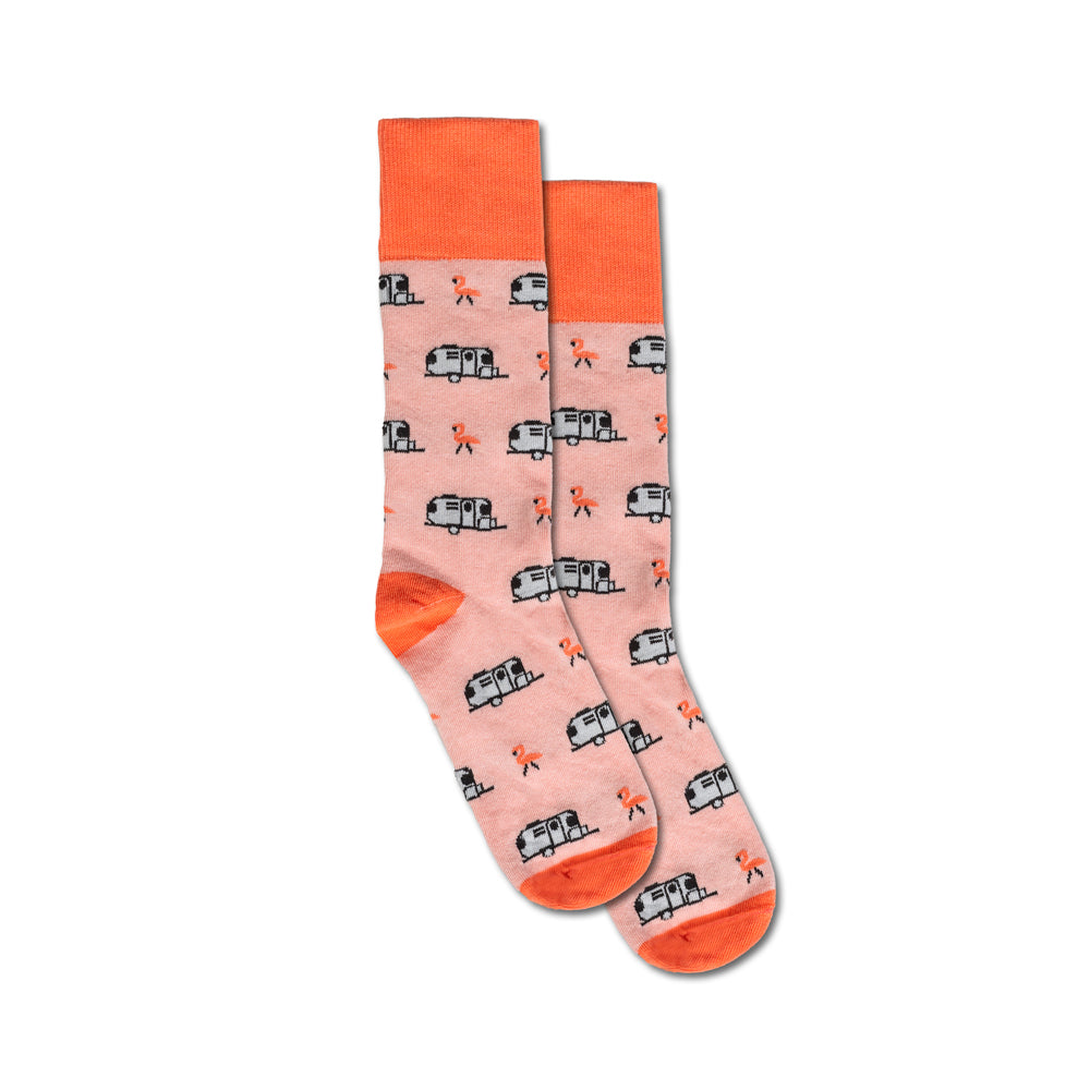 Check out the Airstream Flamingo Trailer Socks: a pair of pink socks with vibrant orange cuffs, heels, and toes, adorned with black-and-white travel trailer patterns and cheerful orange campfire motifs—perfect for adventure seekers or anyone dreaming of life as a pink flamingo on the open road.