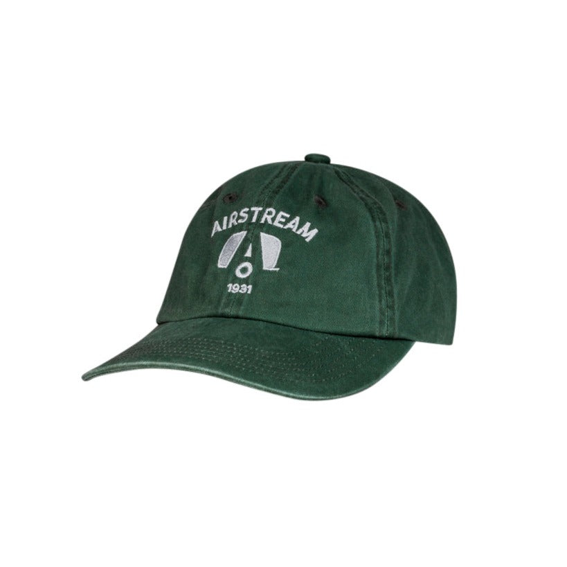 Airstream 1931 Dad Hat – a dark green, pigment-dyed cap featuring “AIRSTREAM 1931” and the logo embroidered in white on the front, displayed at an angle against a white background. This classic hat is perfect for any adventure.