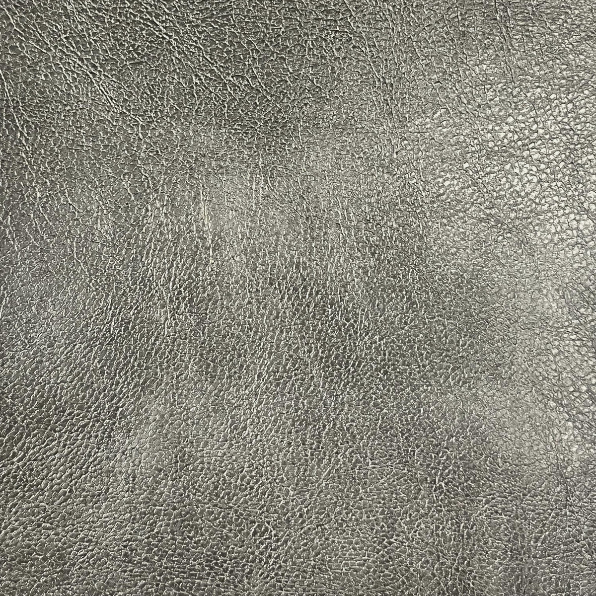 Close-up of a textured gray leather surface with fine, uneven grain patterns and a subtle sheen—perfect for crafting Airstream Custom Replacement Cushion Covers for Basecamp 20 Travel Trailers that deliver both durability and sophisticated style.