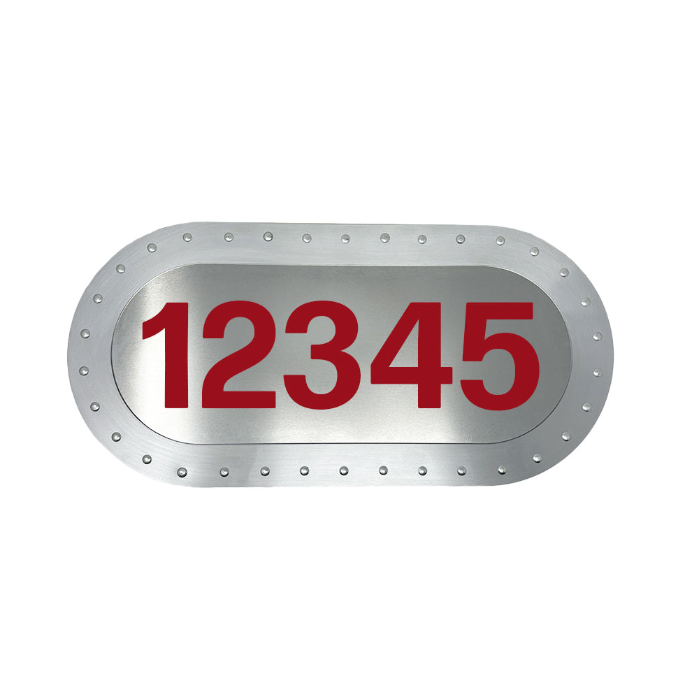 Airstream BRN Plates feature a metallic oval design with edge rivets and showcase bold red numbers—like 12345—in the center, making them perfect for anyone looking for a custom Big Red Numbers aluminum license plate.