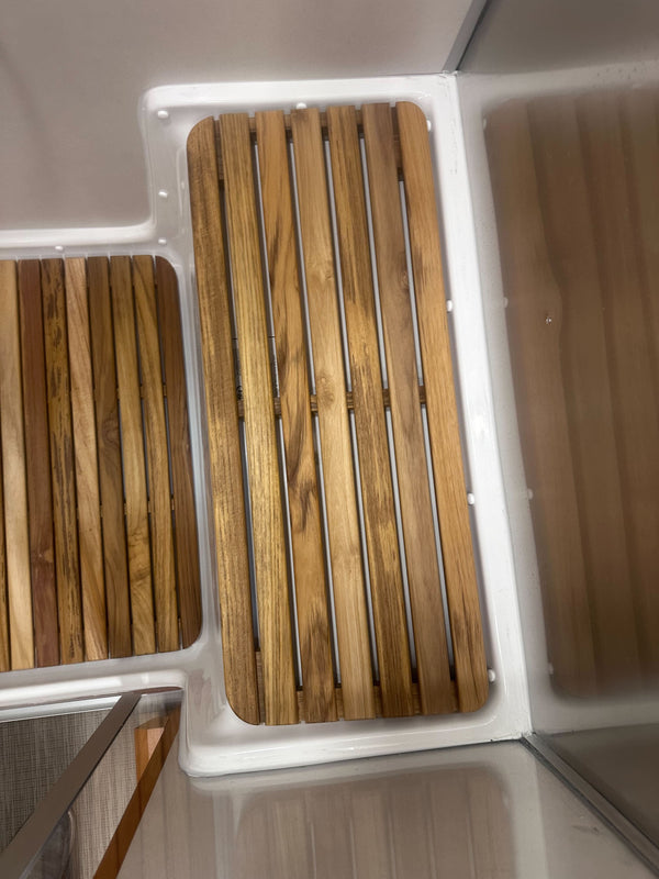 Wooden slatted mat in a white container with foam